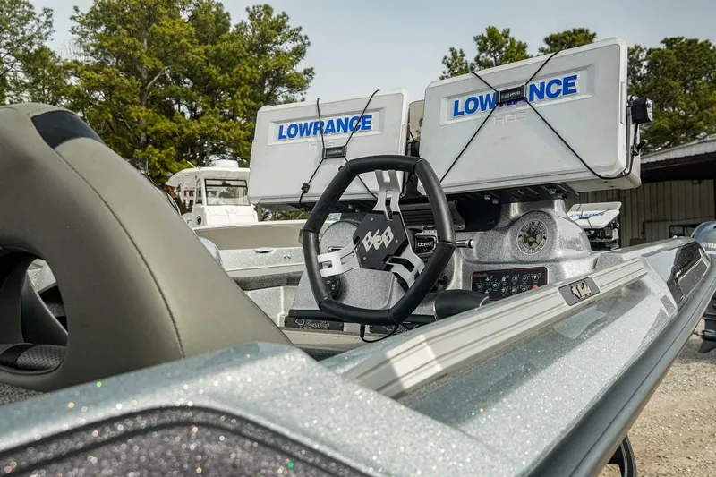 Slide: The Image of 2023 Bass Cat Puma STS boat with Lowrance electronics and steering wheel, outdoors. - 14