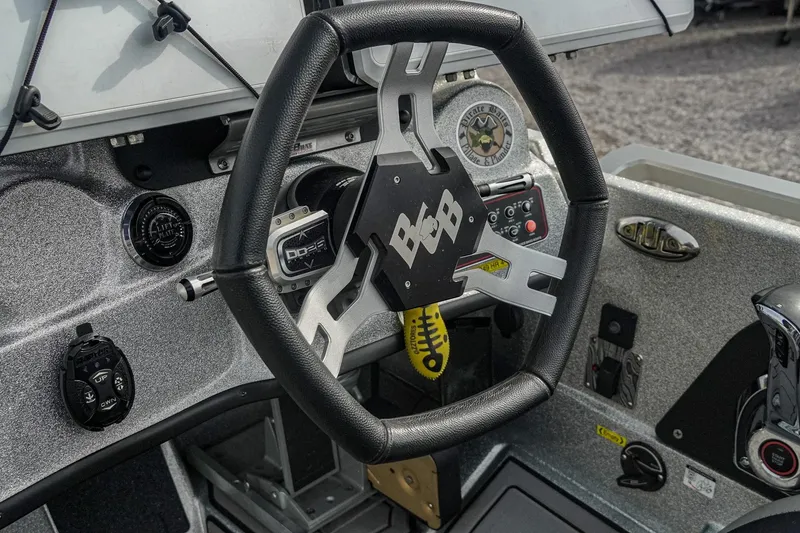 Slide: The Image of 2023 Bass Cat Puma STS boat dashboard with steering wheel and control panel. - 16