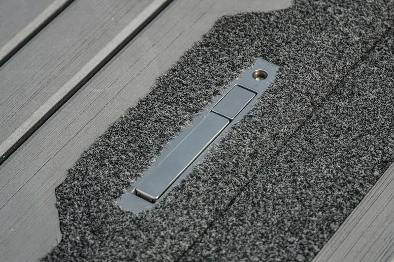 Slide: The Image of 2023 Bass Cat Puma STS carpeted deck with metal latch detail. - 18