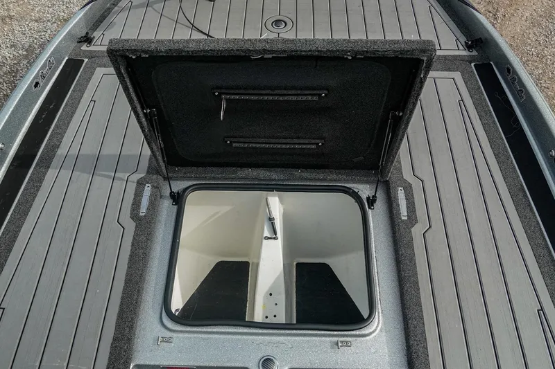 Slide: The Image of 2023 Bass Cat Puma STS boat storage compartment with open lid, showcasing interior space. - 24