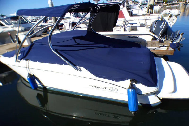 Slide: The Image of 2008 Cobalt 212 boat with blue cover docked at marina. - 1