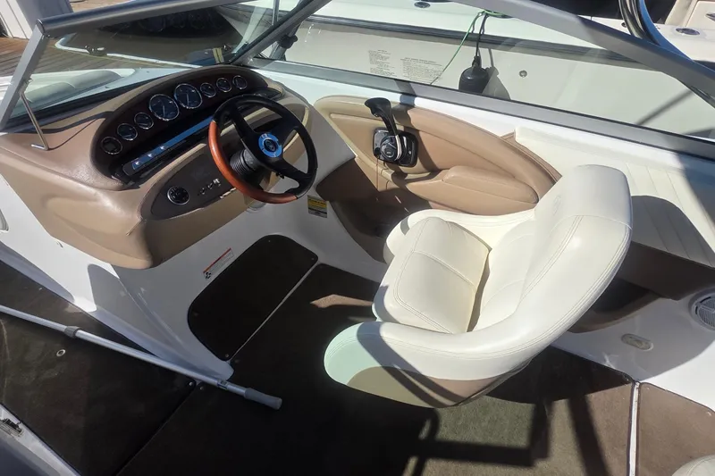 Slide: The Image of 2008 Cobalt 212 boat interior with steering wheel and white captain's chair. - 10