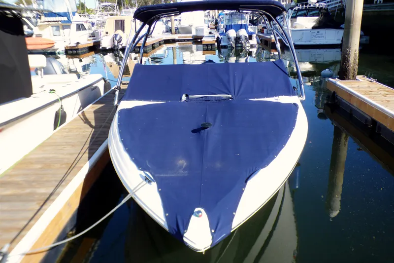 Slide: The Image of 2008 Cobalt 212 boat docked with blue cover in marina. - 21
