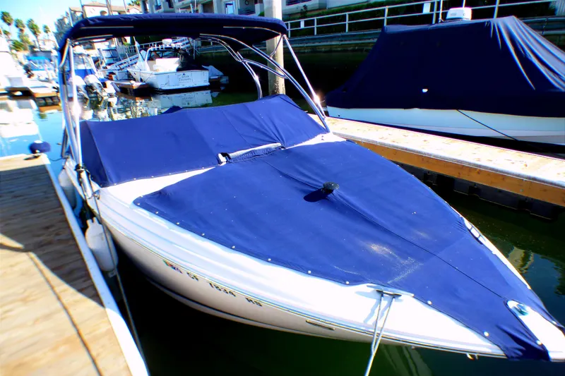 Slide: The Image of 2008 Cobalt 212 boat docked, covered with blue canvas, in a marina setting. - 23