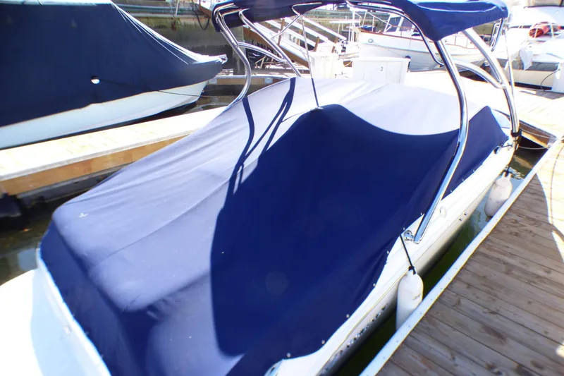 Slide: The Image of Covered 2008 Cobalt 212 boat docked, featuring a blue protective cover and canopy. - 24