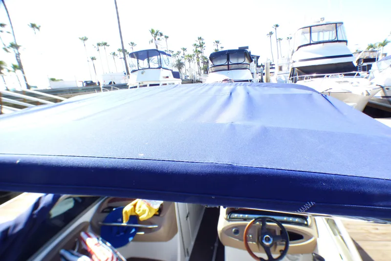 Slide: The Image of 2008 Cobalt 212 boat with blue canopy docked at marina, surrounded by yachts. - 26