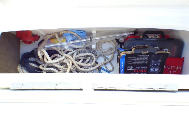 Slide: The Image of Storage compartment in 2008 Cobalt 212 boat with ropes, first aid kit, and marine equipment. - 33