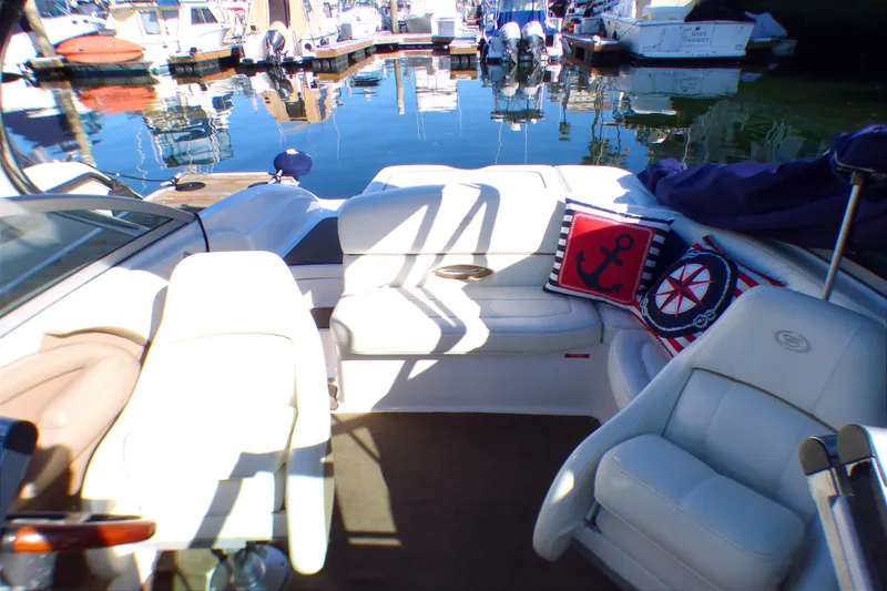 Slide: The Image of Interior of a 2008 Cobalt 212 boat with nautical-themed cushions at a marina. - 5