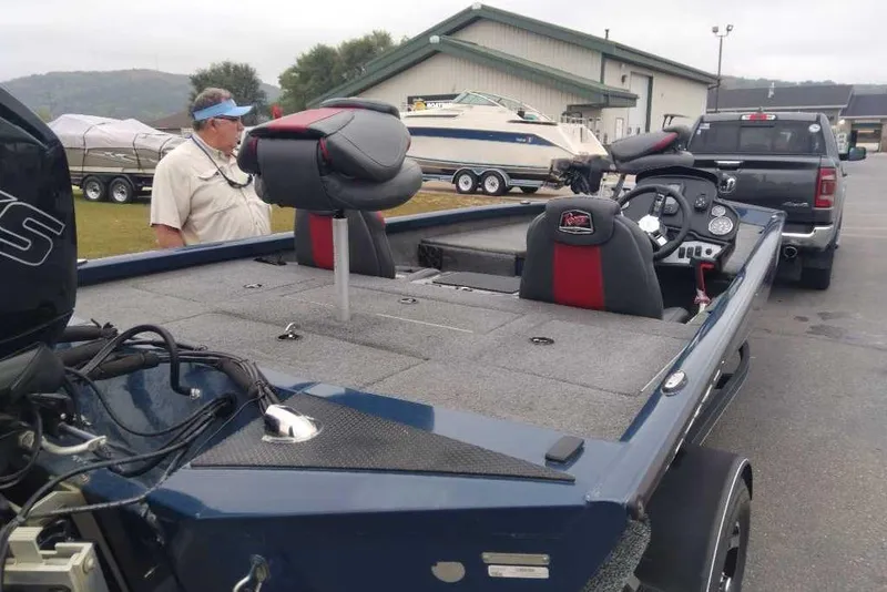 Slide: The Image of 2021 Ranger RT188P fishing boat on trailer, parked near a truck and other boats. - 4