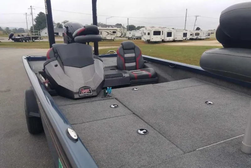 Slide: The Image of 2021 Ranger RT188P fishing boat interior with seating and storage, parked near RVs. - 6