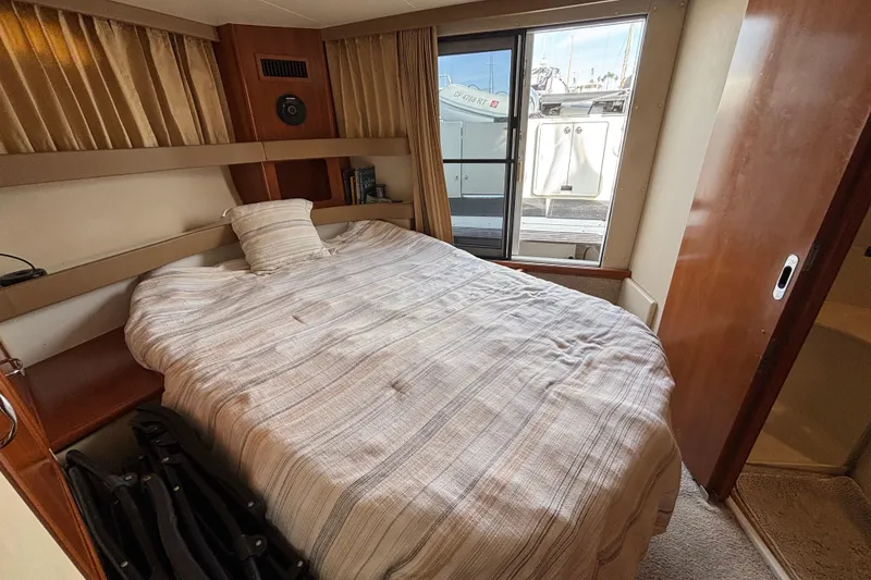 Slide: The Image of 2005 Carver 41 Cockpit Motor Yacht on calm water with city skyline backdrop. - 3