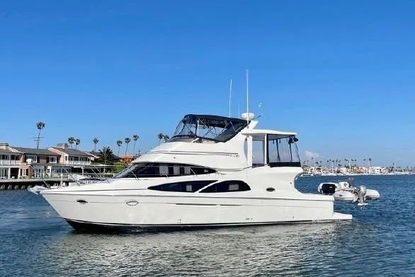 Slide: The Image of 2005 Carver 41 Cockpit Motor Yacht on calm water with city skyline backdrop. - 1