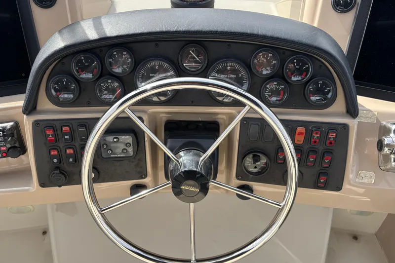Slide: The Image of 2005 Carver 41 Cockpit Motor Yacht dashboard with steering wheel and control gauges. - 13