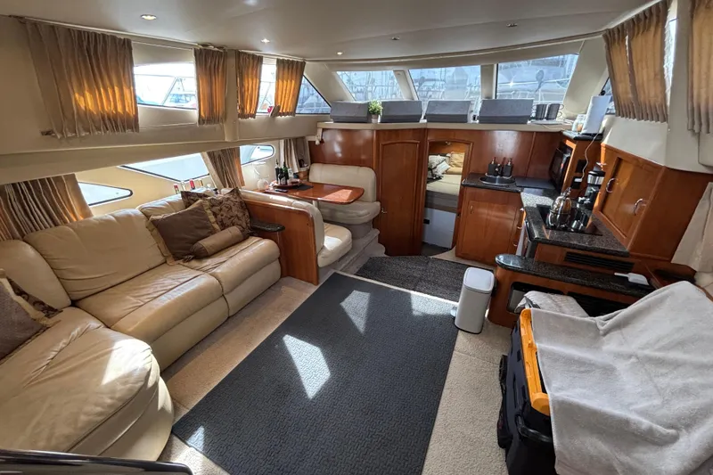 Slide: The Image of Luxurious interior of 2005 Carver 41 Cockpit Motor Yacht with elegant seating and kitchen area. - 9