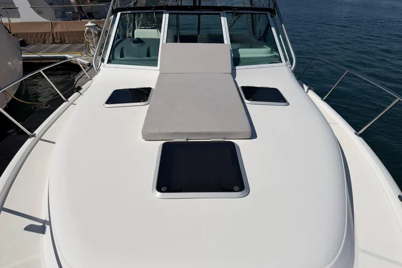 Slide: The Image of 2003 Tiara 3100 Open yacht with sunpad on deck, docked by the water. - 11