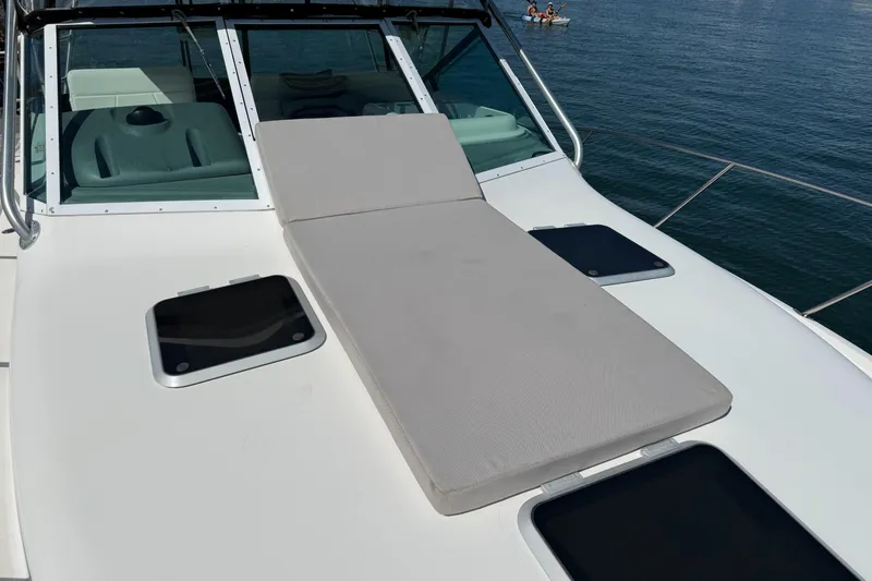 Slide: The Image of 2003 Tiara 3100 Open yacht with sunpad on deck, overlooking calm waters. - 12