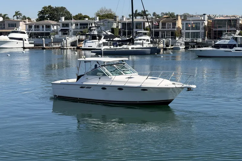 Slide: The Image of 2003 Tiara 3100 Open yacht docked in a marina with waterfront homes. - 19