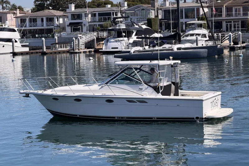 Slide: The Image of 2003 Tiara 3100 Open yacht docked in a marina with waterfront homes. - 21