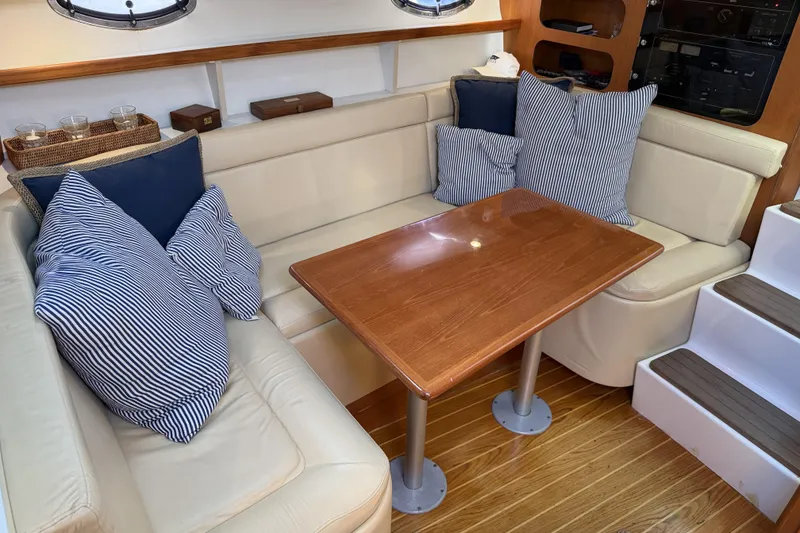 Slide: The Image of Interior of 2003 Tiara 3100 Open yacht with cozy seating and striped cushions. - 5