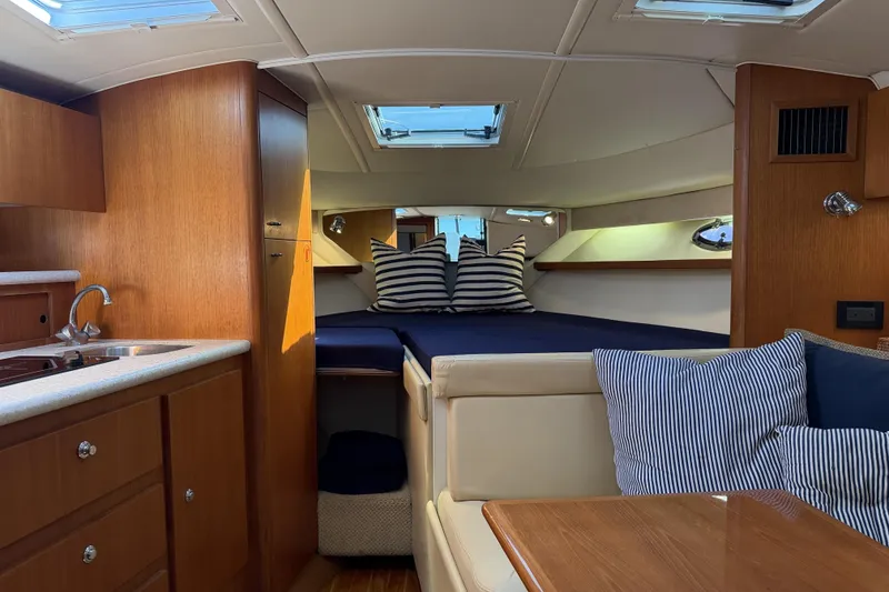 Slide: The Image of Interior of 2003 Tiara 3100 Open yacht with cozy cabin and striped cushions. - 6