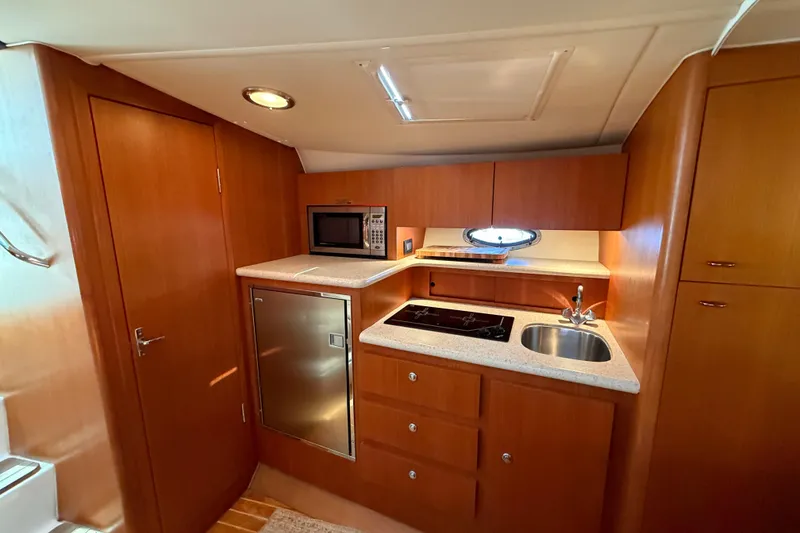 Slide: The Image of 2003 Tiara 3100 Open yacht kitchen with microwave, sink, and stovetop. - 7