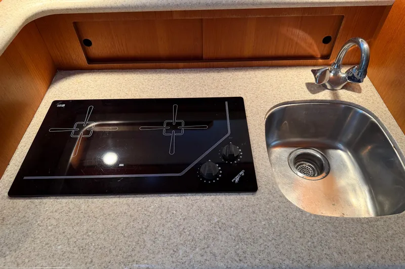 Slide: The Image of Compact kitchen area in a 2003 Tiara 3100 Open boat with stove and sink. - 8