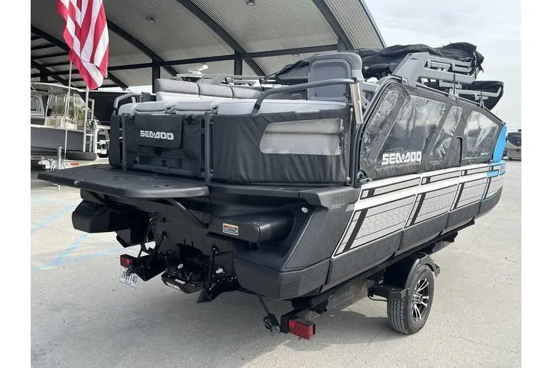 Slide: The Image of 2022 Sea Doo Switch 18 pontoon boat on trailer, parked under a canopy. - 12
