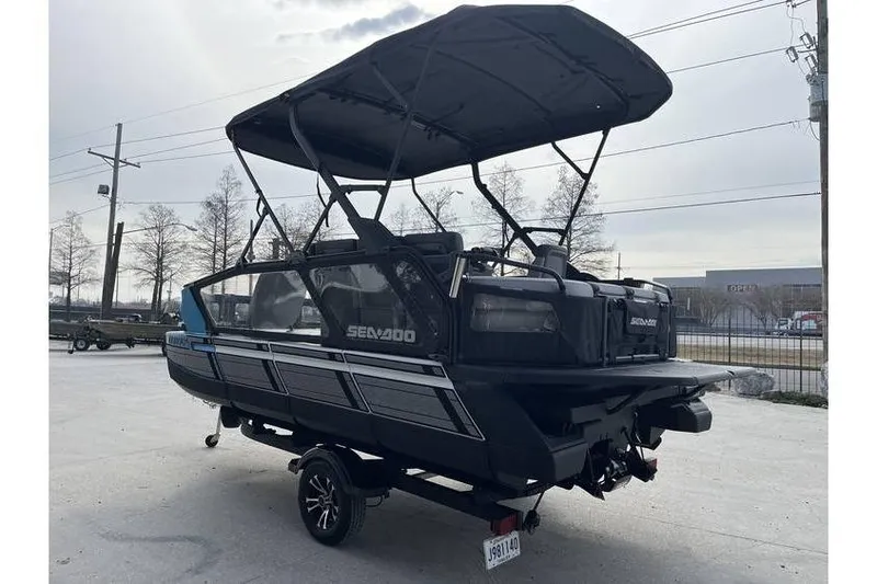 Slide: The Image of 2022 Sea Doo Switch 18 pontoon boat with canopy, parked on a trailer. - 4