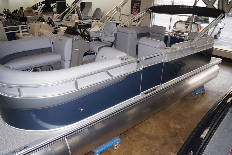 The Image of 2026 Avalon VLS Quad Lounge 21' pontoon boat in showroom, featuring sleek design and spacious seating. - 0