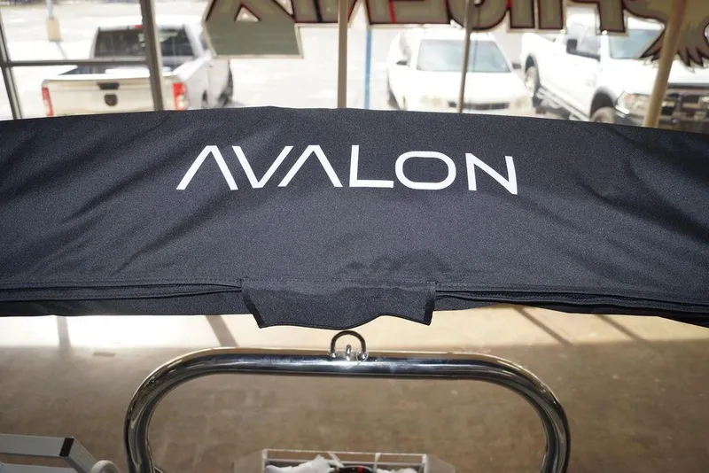 Slide: The Image of 2026 Avalon VLS Quad Lounge boat cover with logo, displayed indoors. - 12