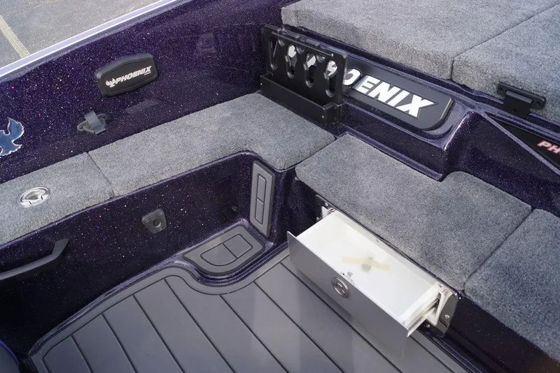 Slide: The Image of 2026 Phoenix 21 XE boat interior with storage compartments and carpeted seating. - 18
