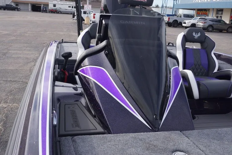 Slide: The Image of 2026 Phoenix 21 XE boat with purple accents and Garmin equipment in a parking lot. - 19