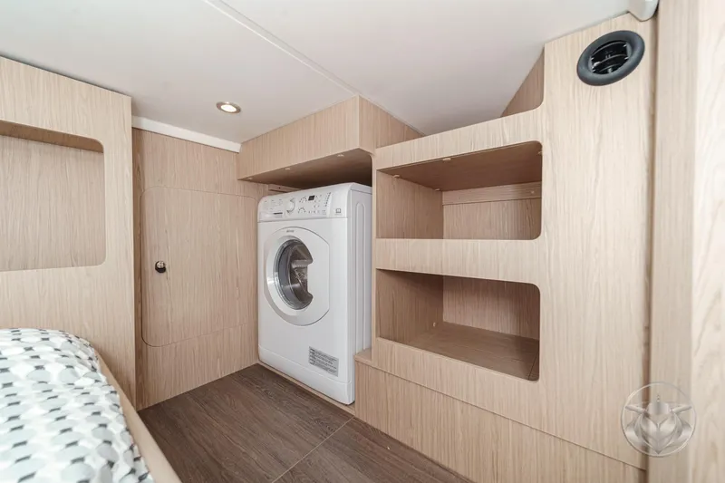 Slide: The Image of Laundry area in 2026 Beneteau Swift Trawler 41 Fly with washer and wooden shelves. - 68