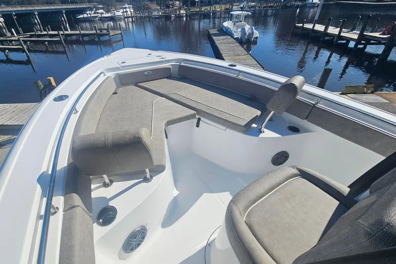 Slide: The Image of 2026 Sea Hunt Ultra 229 boat interior with cushioned seating, docked at a marina. - 15