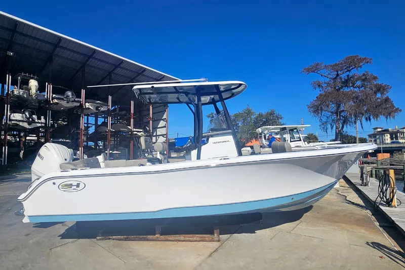 Slide: The Image of 2026 Sea Hunt Ultra 229 boat docked under a clear blue sky. - 5