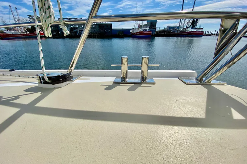 Slide: The Image of Boat deck view with metal railings, docked ships, and clear blue sky. Wellington 44, 1980. - 13