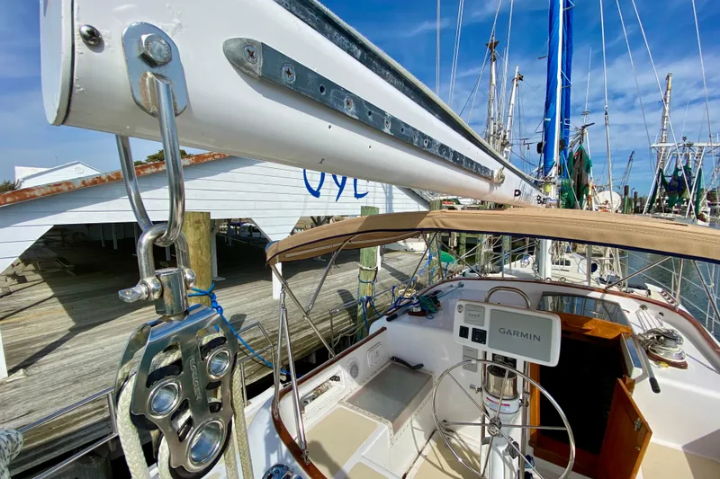 Slide: The Image of 1980 Wellington 44 sailboat cockpit with Garmin navigation, docked at marina under clear sky. - 15