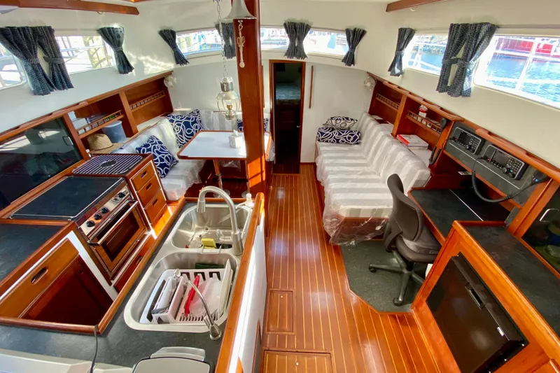 Slide: The Image of Interior of a 1980 Wellington 44 yacht with kitchen, seating, and navigation area. - 21