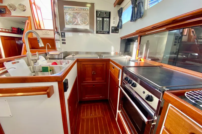 Slide: The Image of Galley kitchen in 1980 Wellington 44 yacht with wood cabinetry and modern appliances. - 23