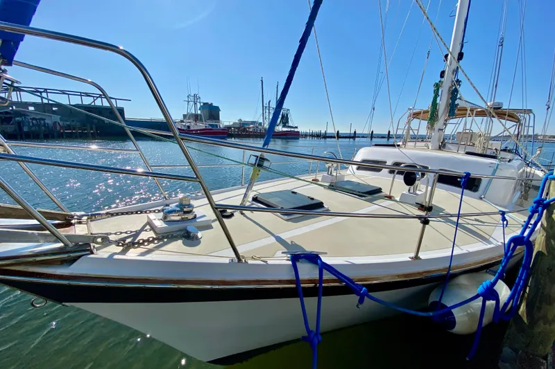 Slide: The Image of 1980 Wellington 44 sailboat docked in sunny marina, showcasing deck and rigging. - 4