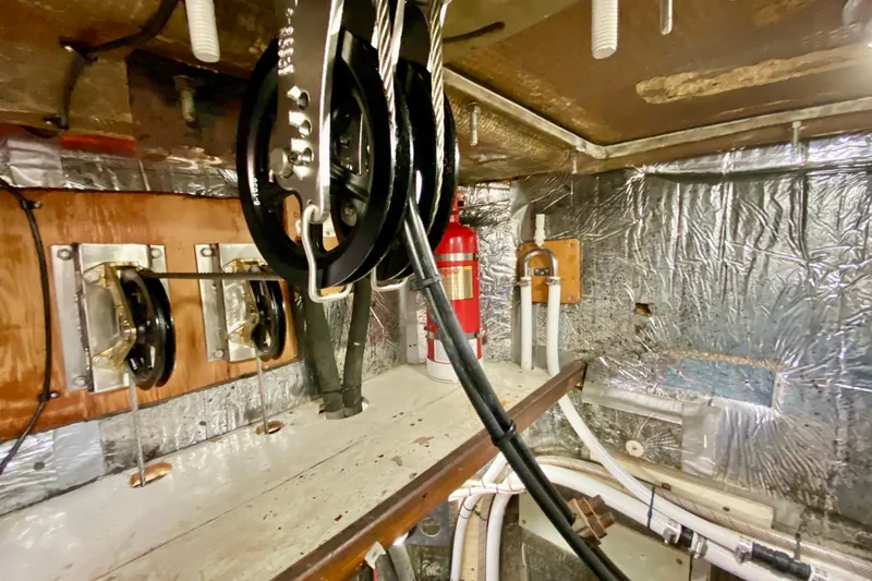 Slide: The Image of Engine room of 1980 Wellington 44 yacht with pulleys, cables, and fire extinguisher. - 47