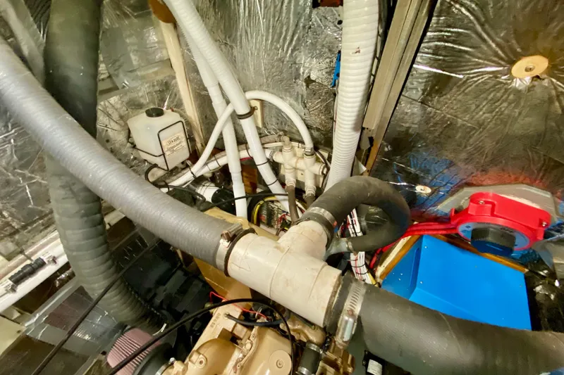 Slide: The Image of Engine room of 1980 Wellington 44 yacht with hoses and mechanical components. - 48