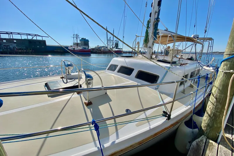 Slide: The Image of 1980 Wellington 44 sailboat docked at marina under clear blue sky. - 5