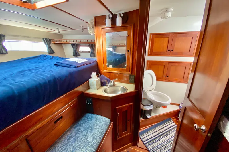 Slide: The Image of Cozy 1980 Wellington 44 yacht cabin with bed, sink, and bathroom. - 50