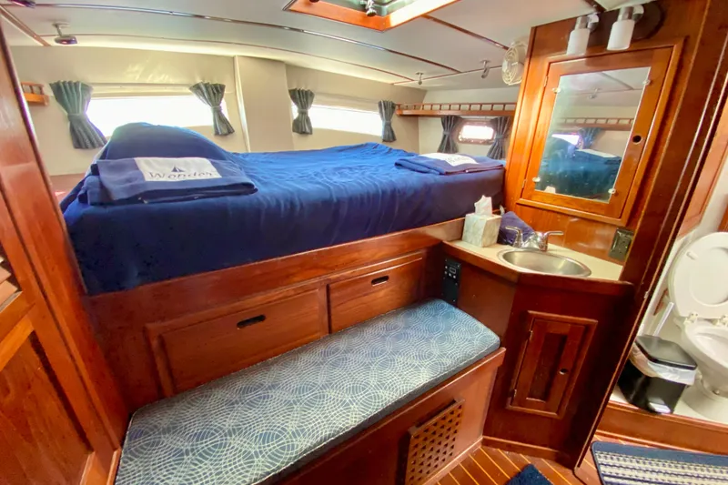 Slide: The Image of Cozy 1980 Wellington 44 yacht cabin with bed, sink, and wooden interior. - 51