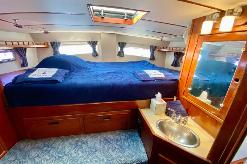 Slide: The Image of Cozy 1980 Wellington 44 yacht cabin with bed, sink, and wooden cabinetry. - 53