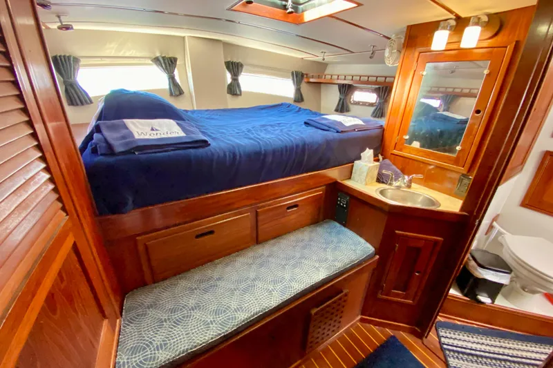 Slide: The Image of Luxurious cabin interior of 1980 Wellington 44 yacht with bed, sink, and wooden furnishings. - 54