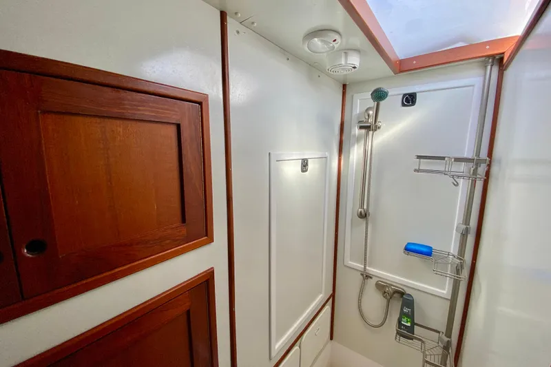 Slide: The Image of 1980 Wellington 44 yacht bathroom with wooden cabinets and modern shower fixtures. - 57