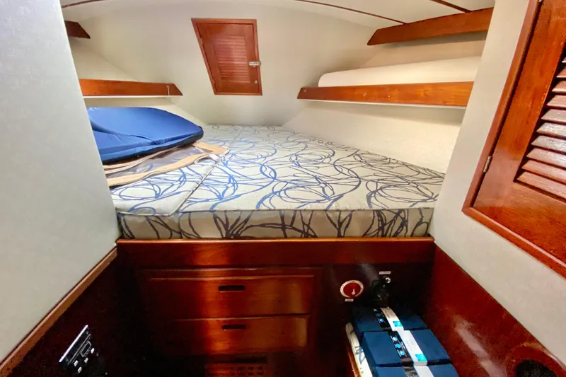 Slide: The Image of Cozy cabin interior of 1980 Wellington 44 sailboat with patterned bedding and wooden accents. - 64