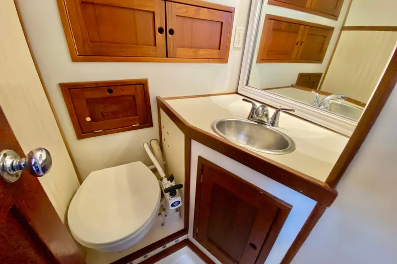 Slide: The Image of Compact bathroom in 1980 Wellington 44 yacht with wooden cabinets and stainless steel sink. - 66